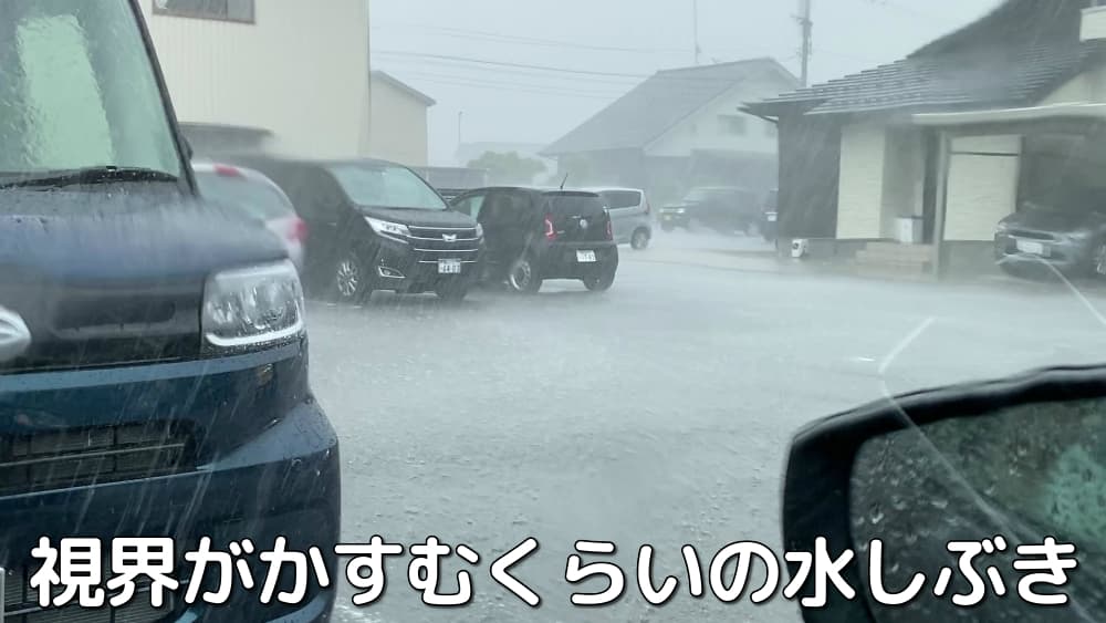 ゲリラ豪雨に打たれる駐車場の車